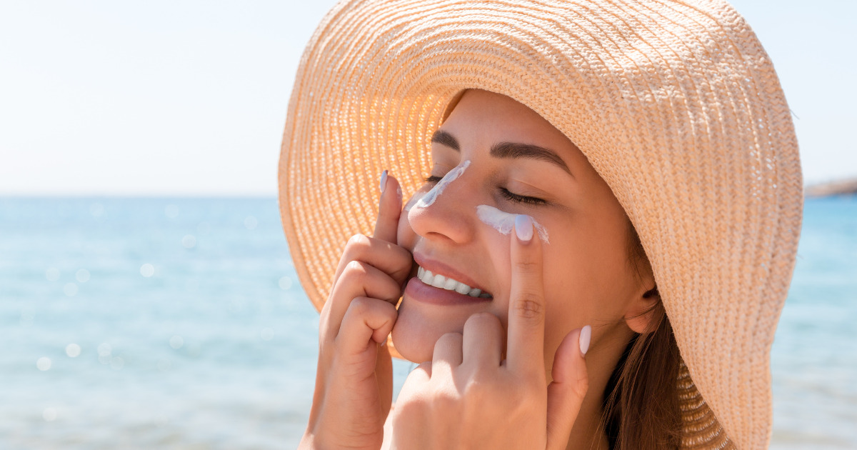 image of a woman putting on sunscreen