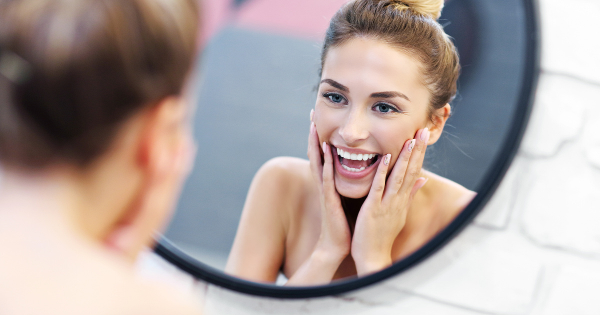 beautiful woman smiling in a mirror