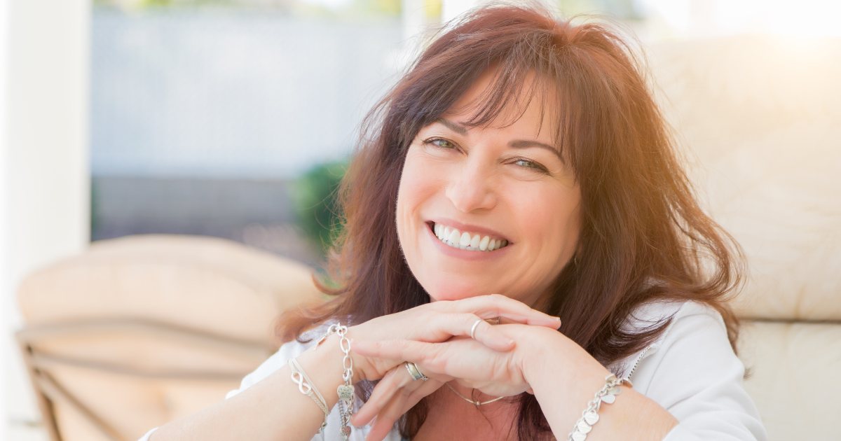 A happy woman in her 50s with flawless skin.